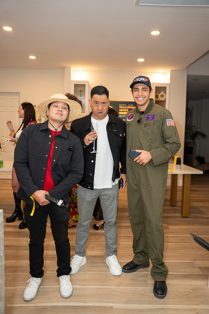 Three friends in cowboy, casual, and flight-suit costumes posing together