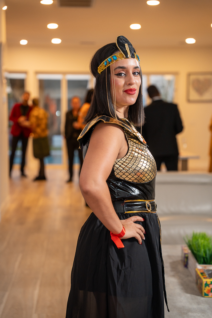 A guest in a black-and-gold Egyptian-inspired gown posing at the mixer