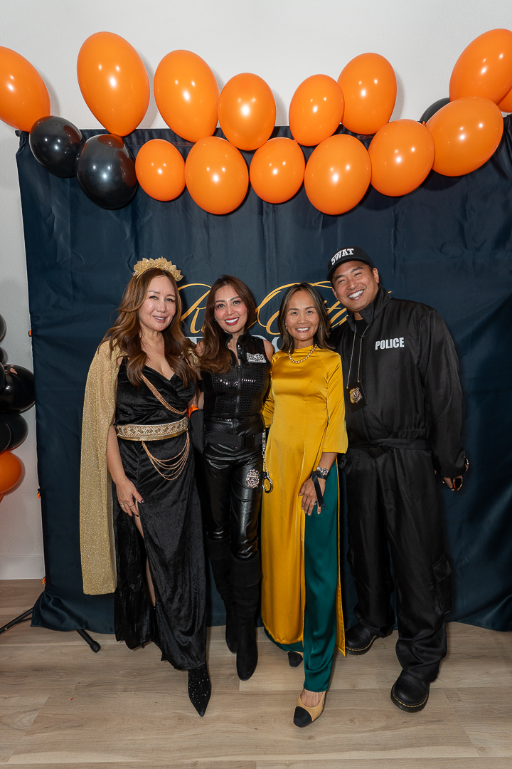 Four friends posing at the backdrop with a guest in a police costume