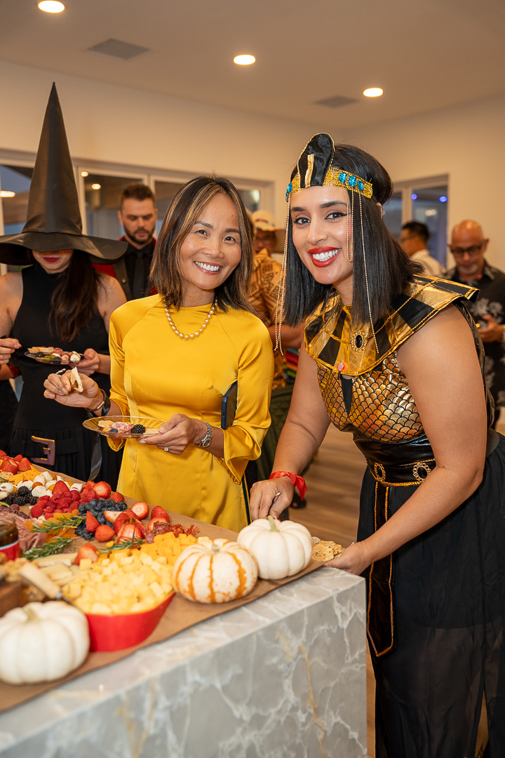 Friends in yellow and Egyptian-inspired costumes posing beside the food spread