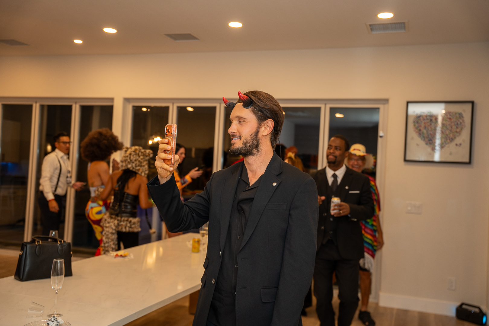 A guest in a dark suit chatting with friends at the REFC celebration