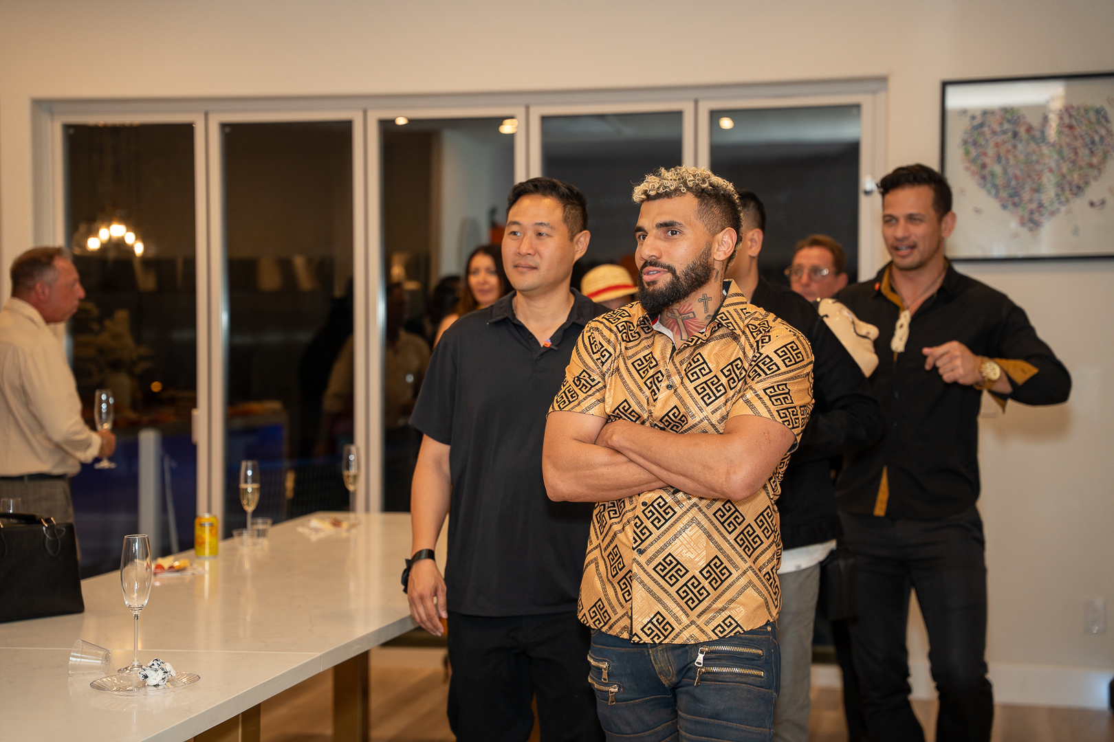 Three friends chatting beside the kitchen island during the anniversary mixer