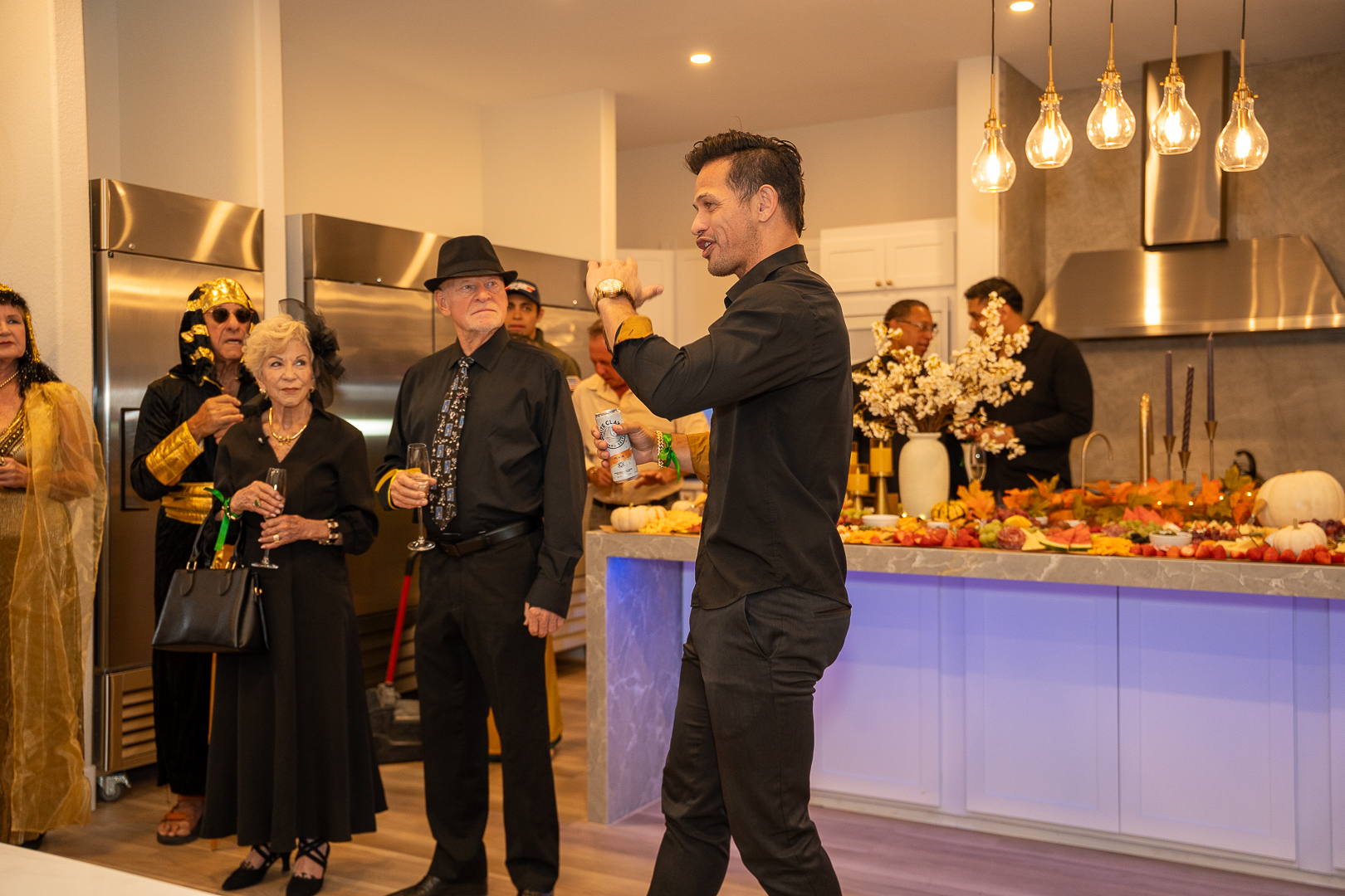 Guests gathering beside the food spread while a friend takes a phone photo