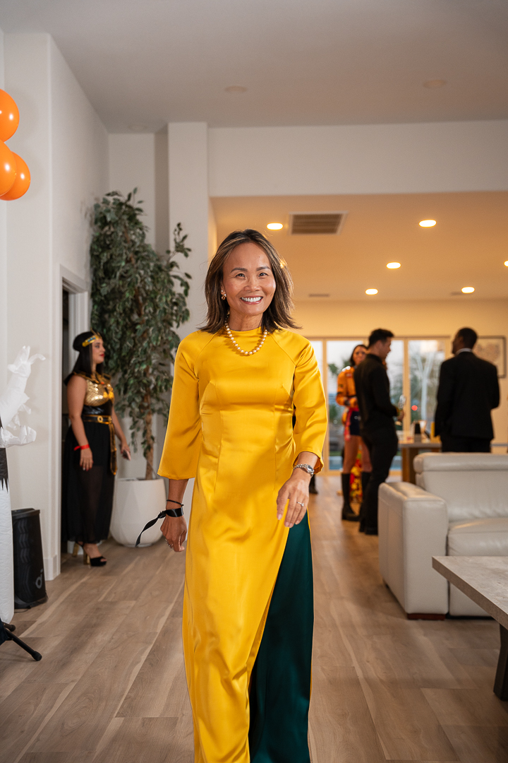 A guest in a yellow áo dài and green trousers posing at the celebration