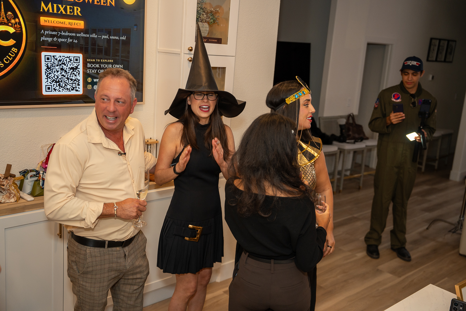Costumed guests chatting beside the kitchen island at the REFC mixer