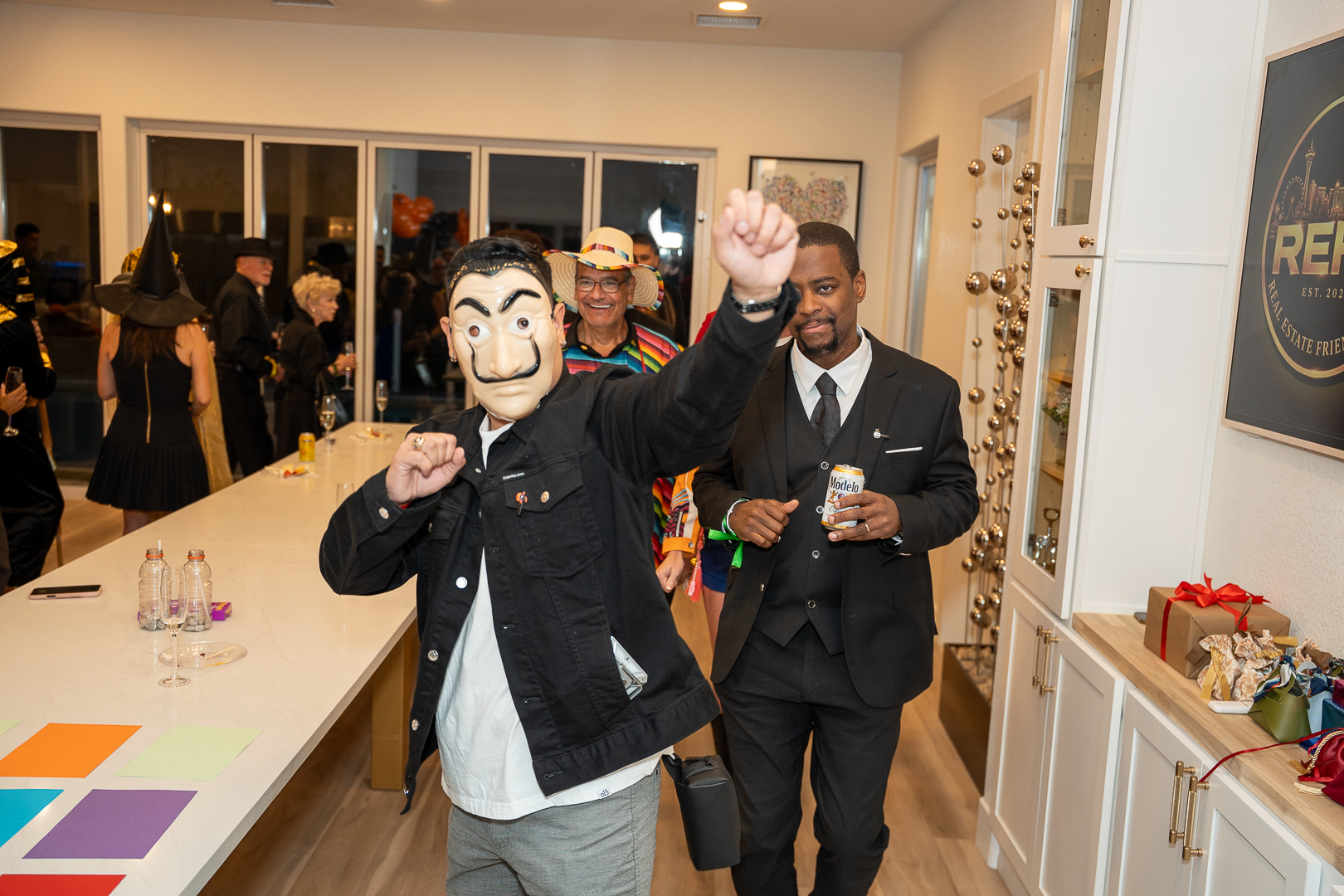 A masked guest dancing with friends raising their cups