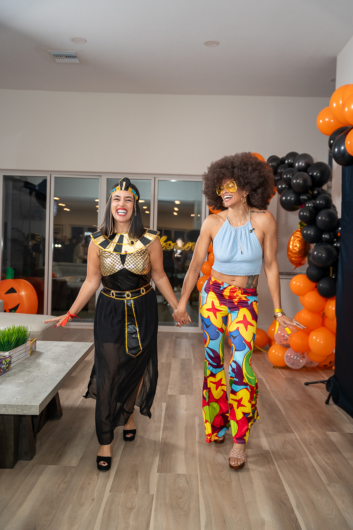 Friends in Egyptian and disco-inspired costumes walking hand in hand