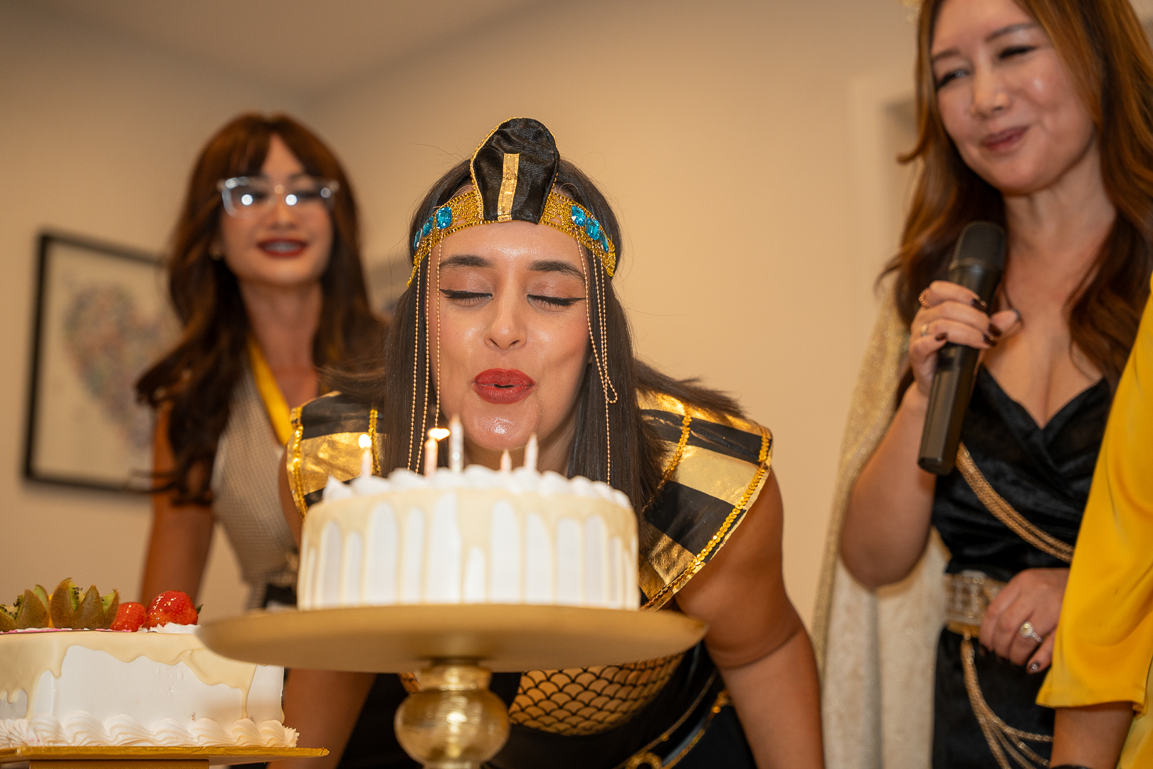 A guest in an Egyptian-inspired costume with the cake for REFC's first year