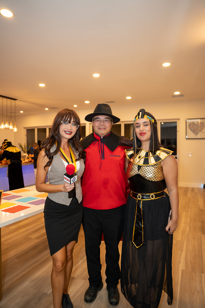 Guests in reporter, cowboy, and Egyptian-inspired costumes posing together at the mixer