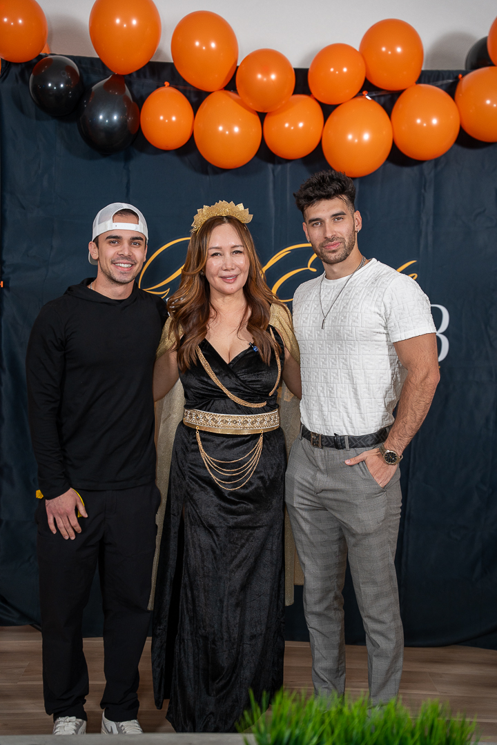 A couple in costume posing in front of the REFC balloon backdrop