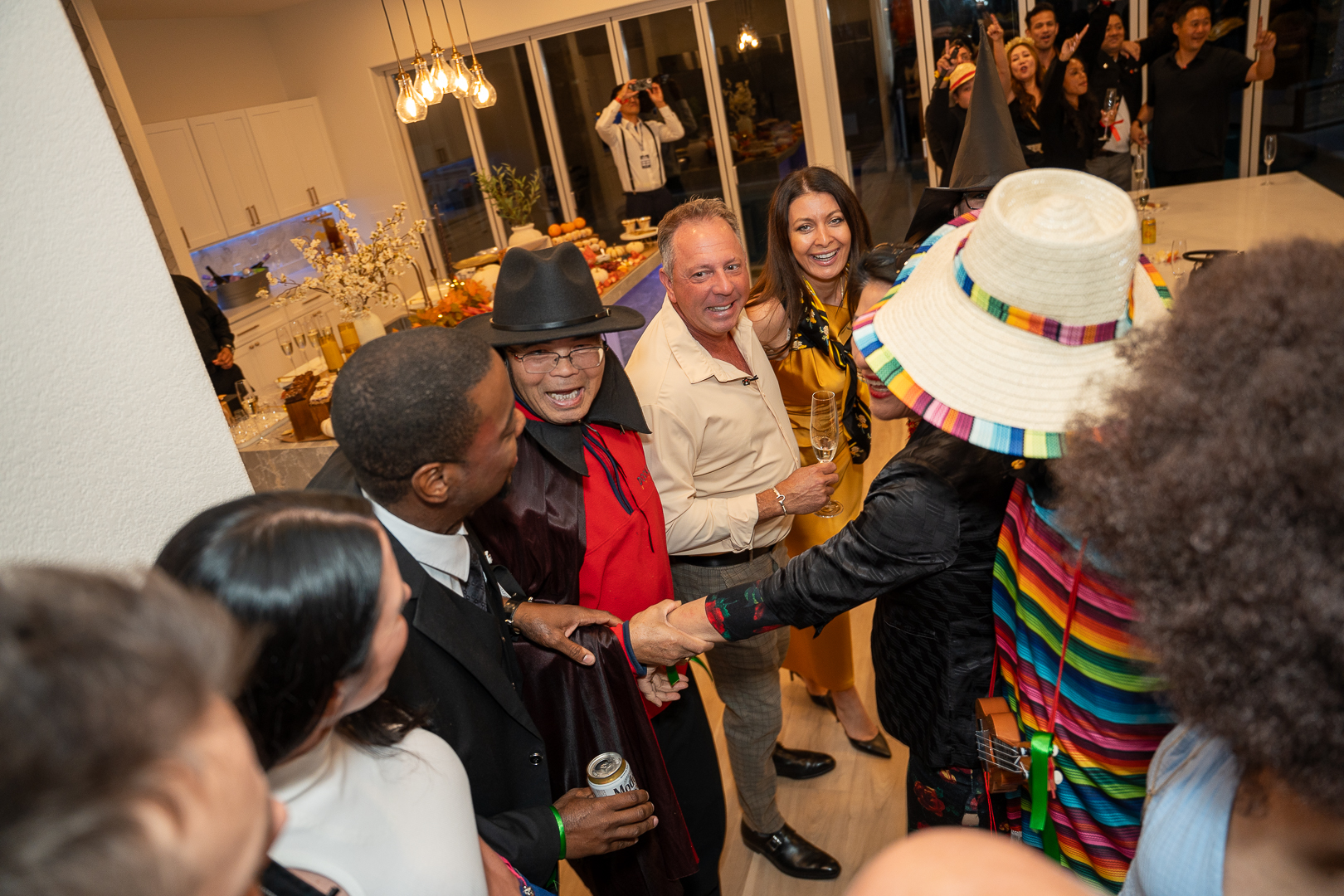 Costumed guests laughing together beside the kitchen island