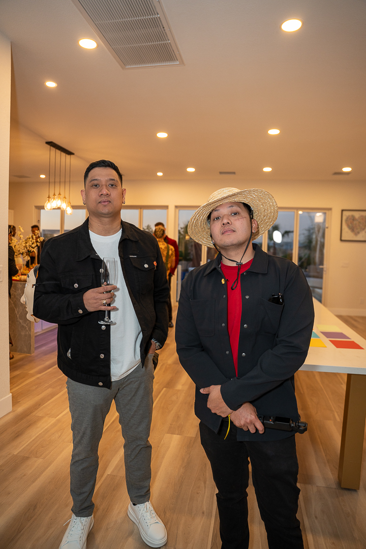 Two guests in a dark jacket and cowboy costume posing in the kitchen