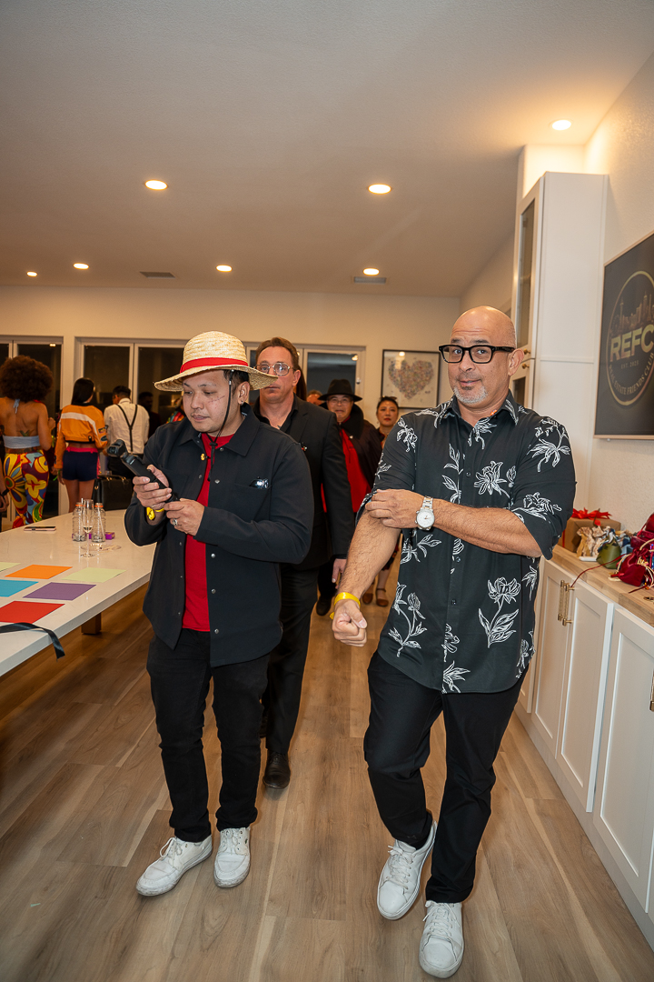Two guests enjoying drinks beside the kitchen island during the REFC celebration