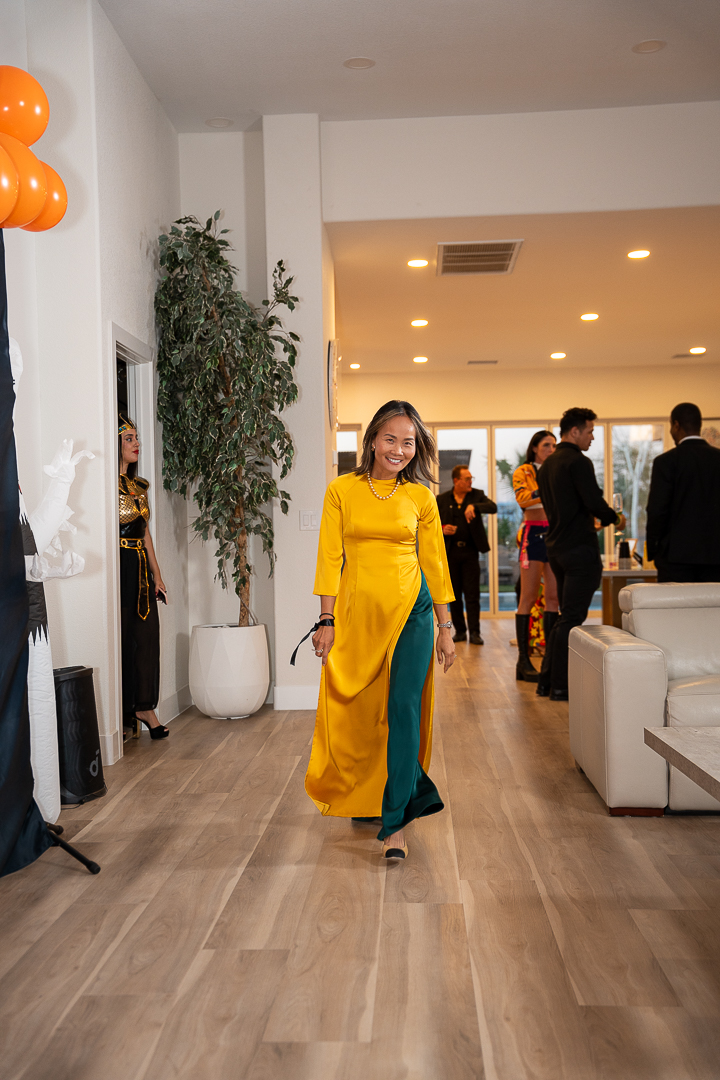 A guest in a yellow áo dài walking through the mixer