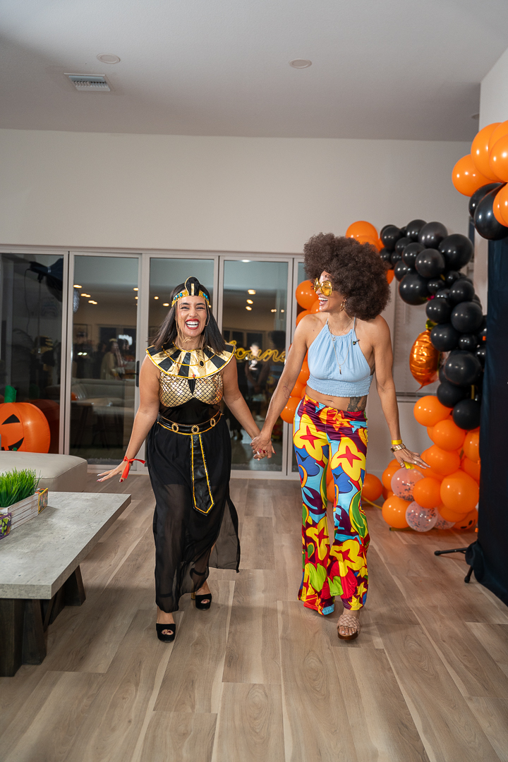Smiling guests in Egyptian-inspired and disco costumes enjoying the Halloween celebration