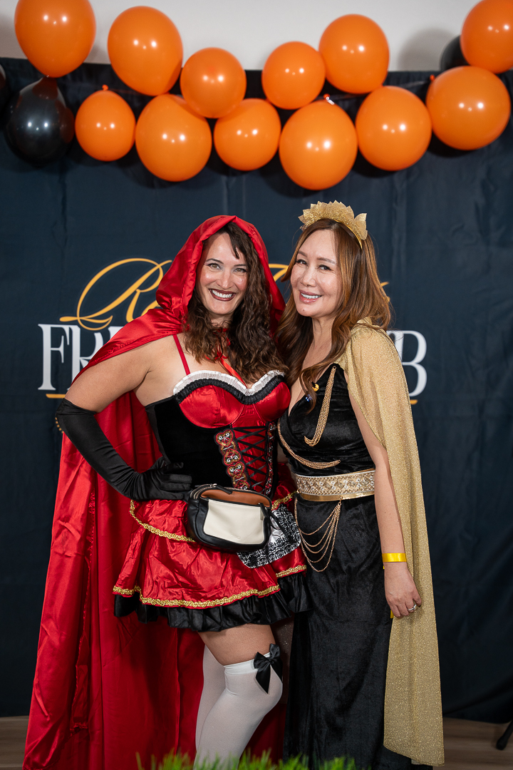 Little Red Riding Hood and the queen-costumed hostess posing at the backdrop