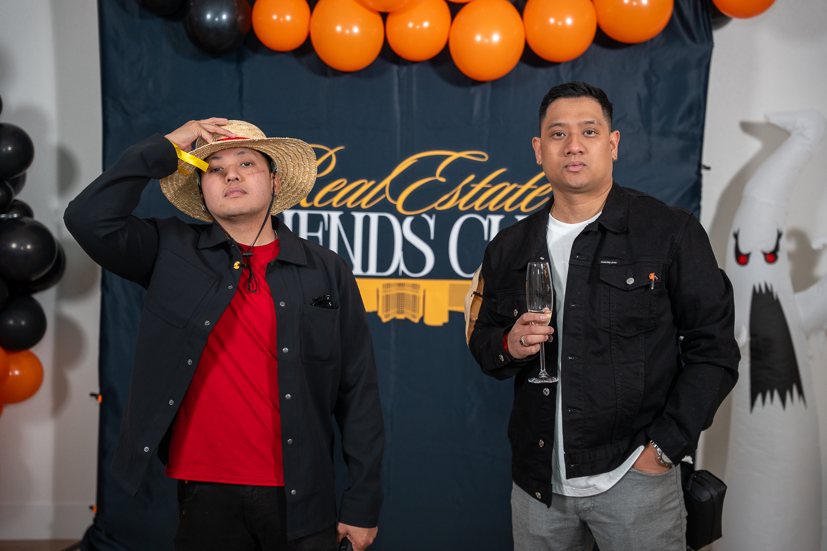 Two guests in vampire and suit costumes posing at the REFC backdrop