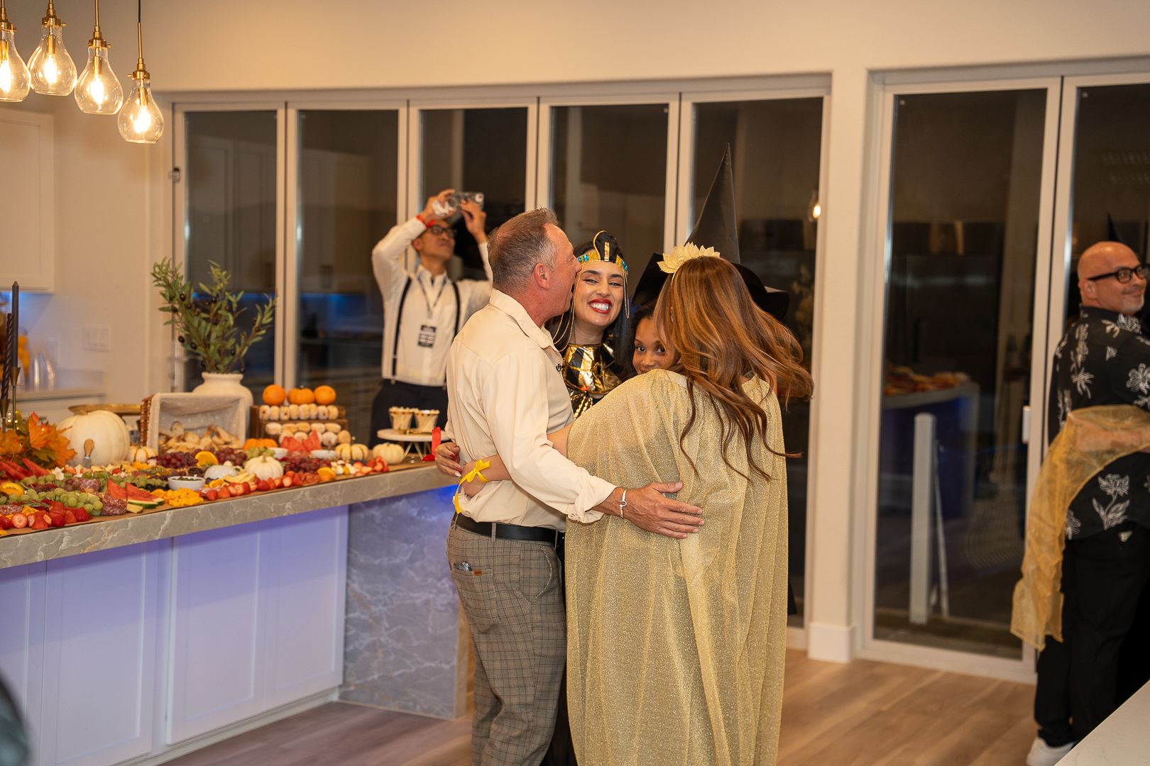 Two guests embracing beside the food spread during REFC's anniversary celebration