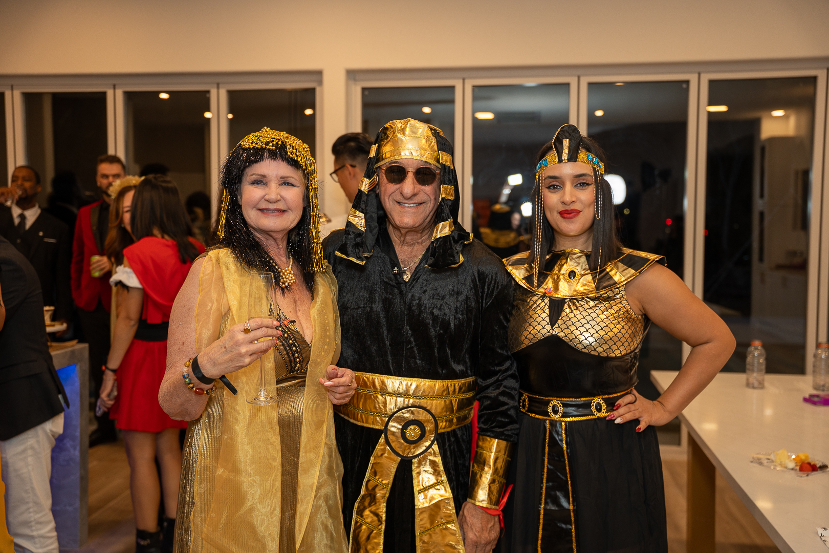 Three guests in gold and Egyptian-inspired costumes posing at the mixer