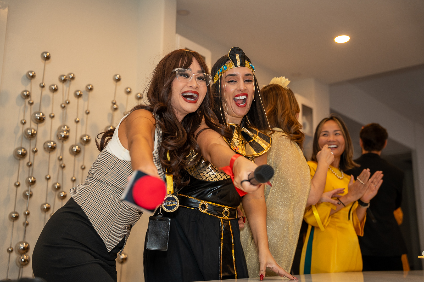 Costumed friends singing and celebrating with microphones at the REFC mixer