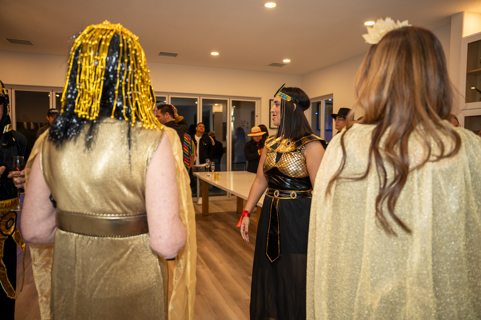 Costumed friends mingling in the kitchen during the REFC celebration