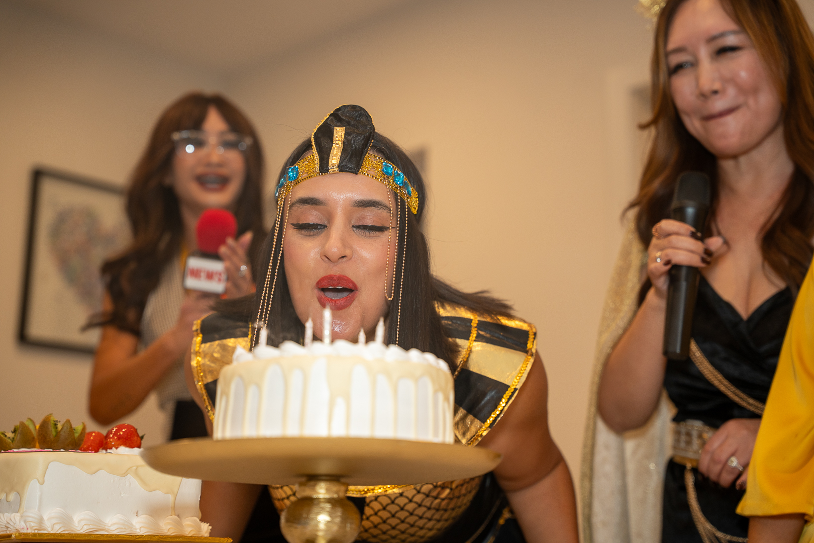 Friends watching as the candles are blown out on REFC's anniversary cake