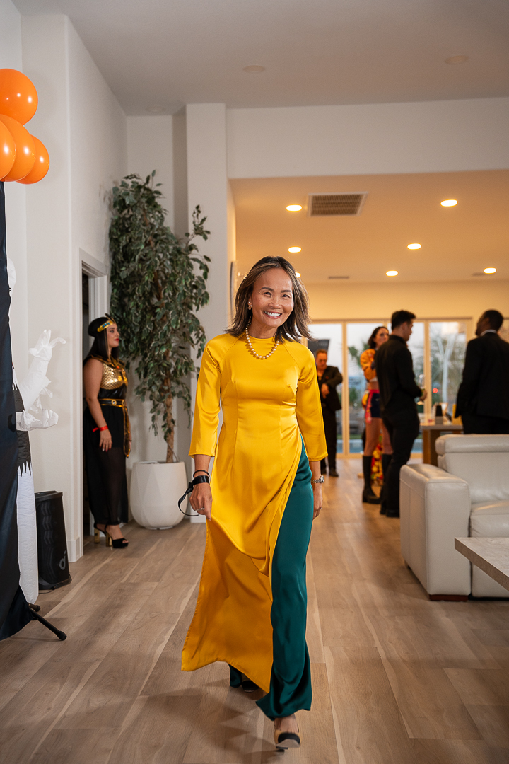 A guest in a yellow áo dài smiling as she walks through the mixer