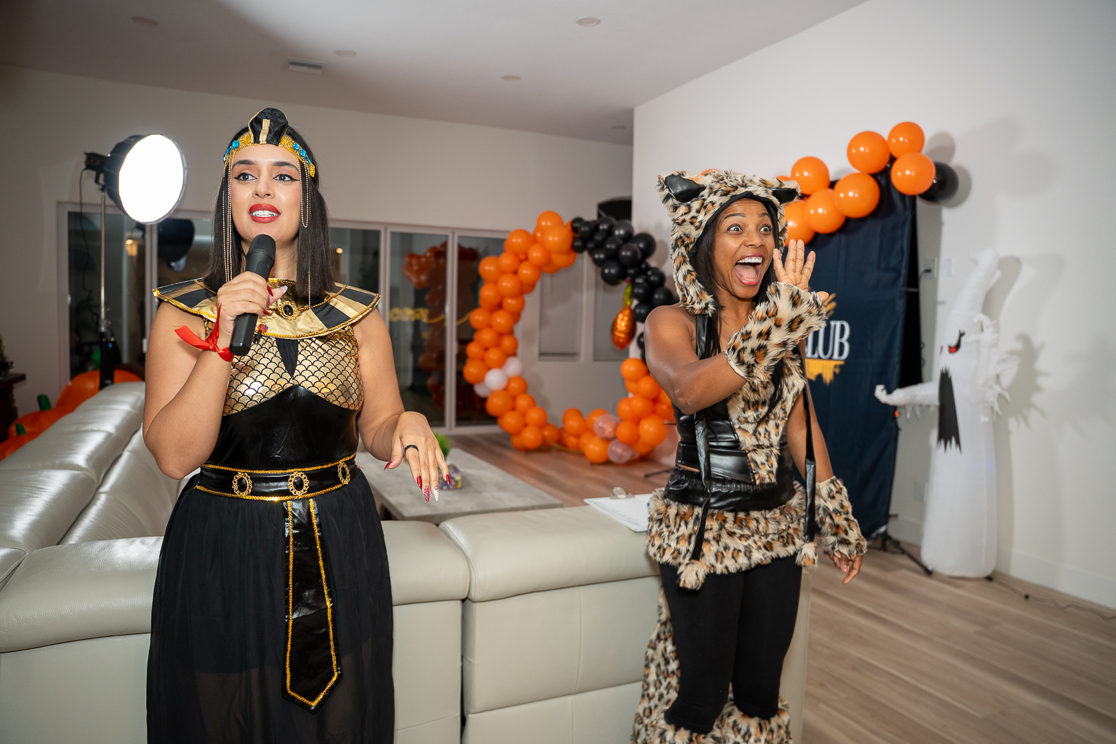 Two guests in Egyptian-inspired costumes dancing at the REFC mixer