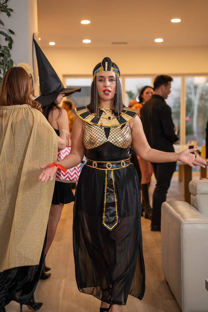A guest in an Egyptian-inspired gown welcoming friends to the celebration