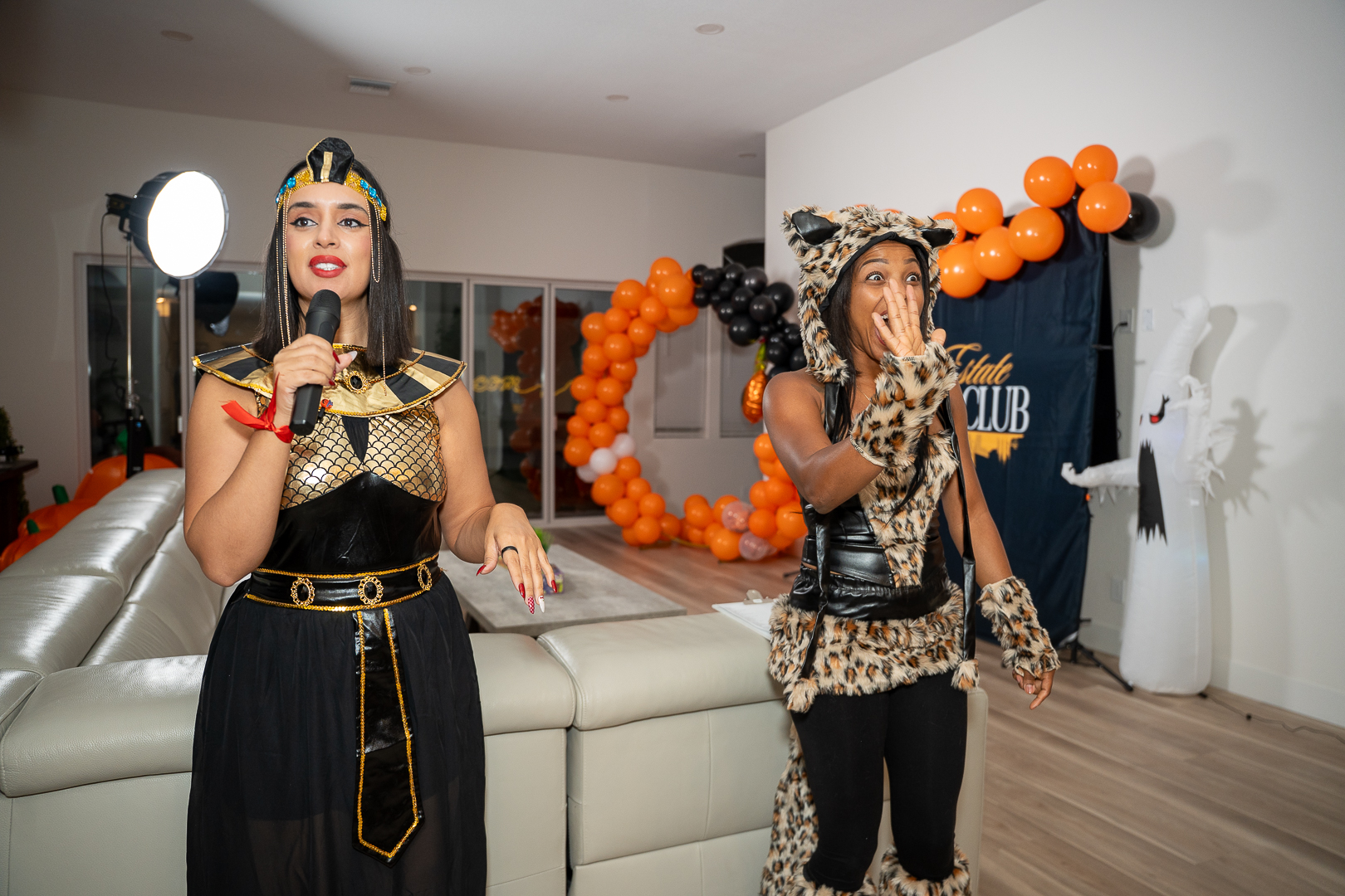 Two guests in Egyptian-inspired costumes raising their drinks