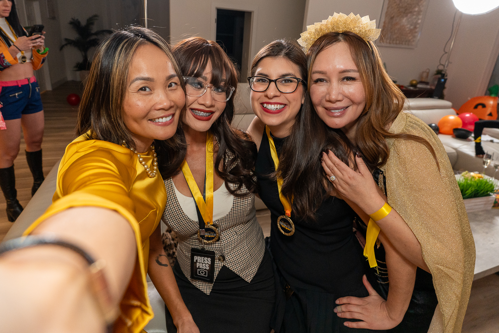 Four friends taking a cheerful group selfie at the REFC Halloween mixer