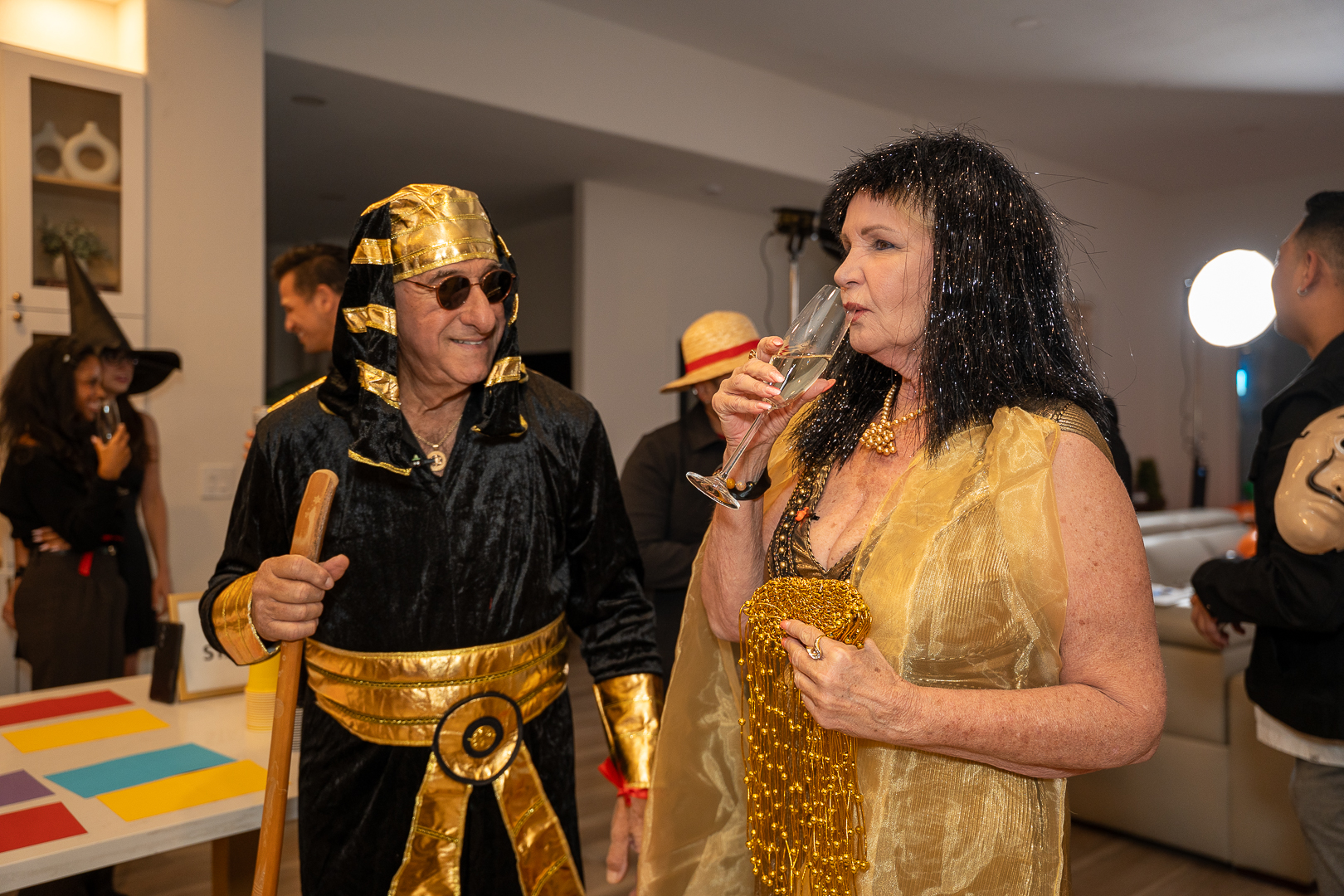 Guests in Egyptian-inspired and gold costumes enjoying refreshments