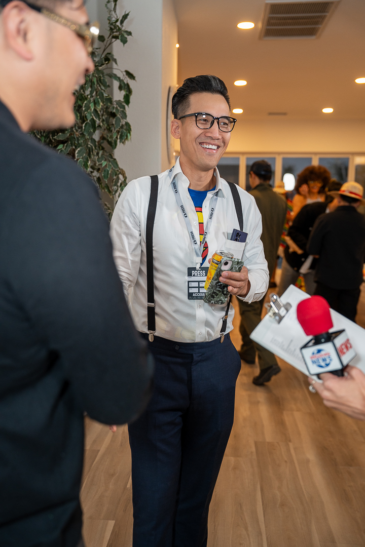 A guest dressed as a news reporter with a press badge
