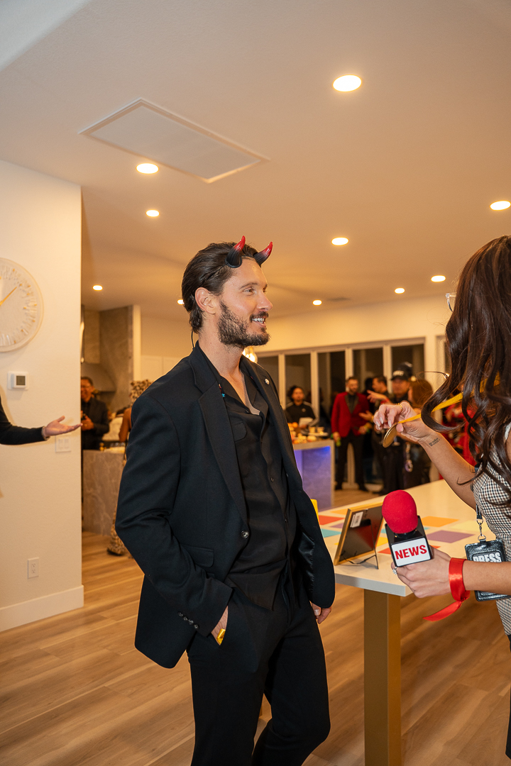 A guest in a black suit chatting beside the kitchen island
