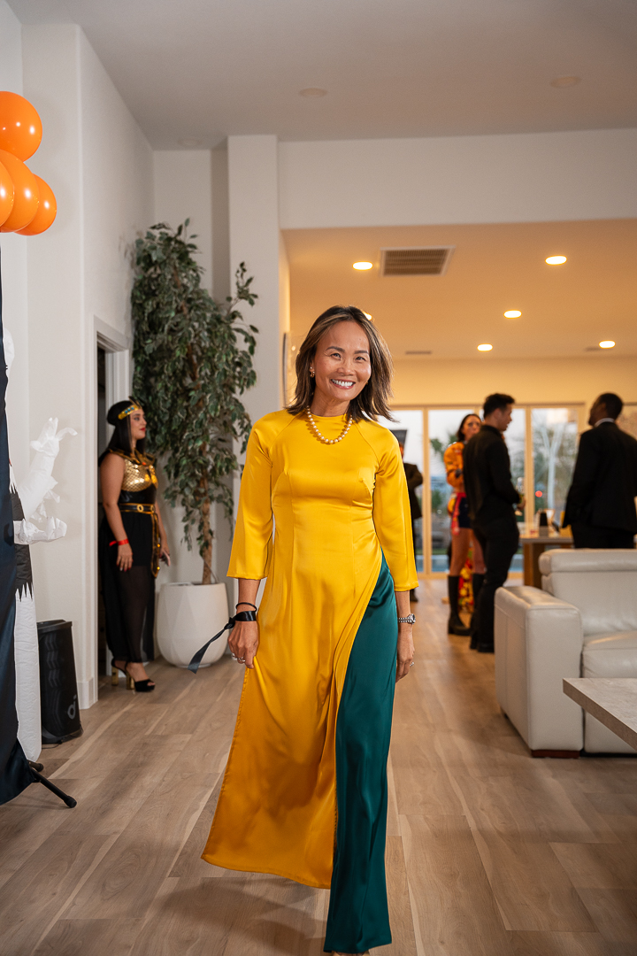 A guest in a yellow áo dài and green trousers enjoying the celebration