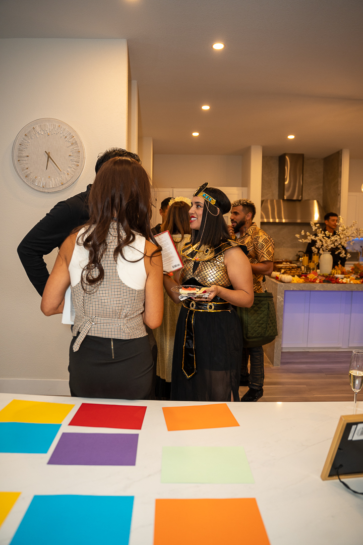 Guests in reporter and Egyptian-inspired costumes chatting at the mixer