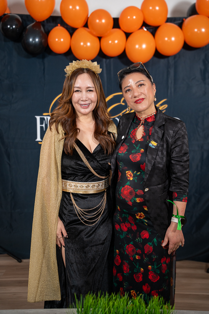 Two guests posing in front of the REFC backdrop