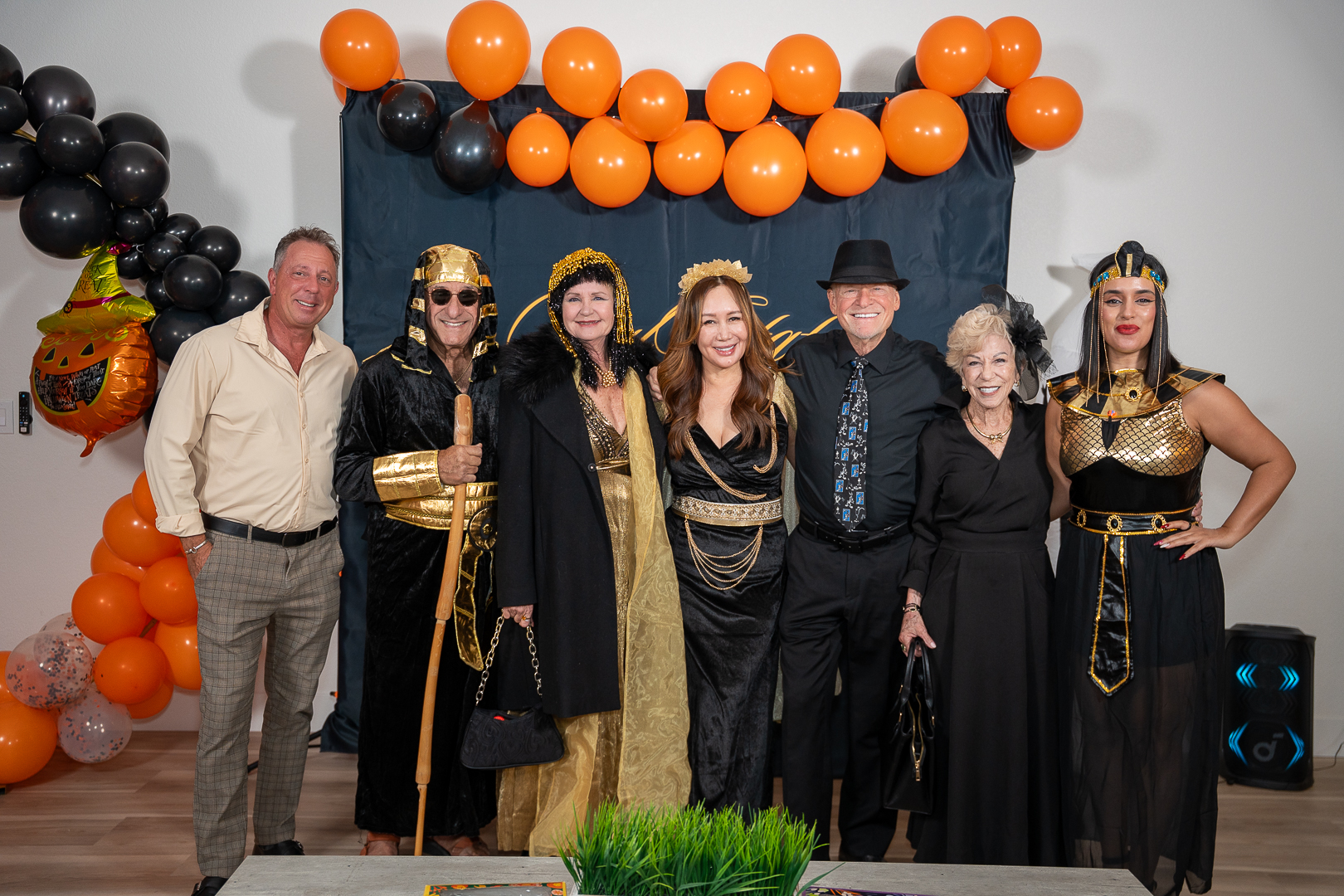 Costumed guests gathered for a group portrait beneath the REFC balloon arch