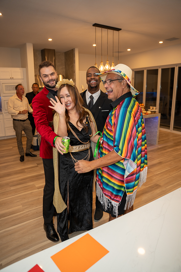 Costumed friends posing together beside the kitchen island