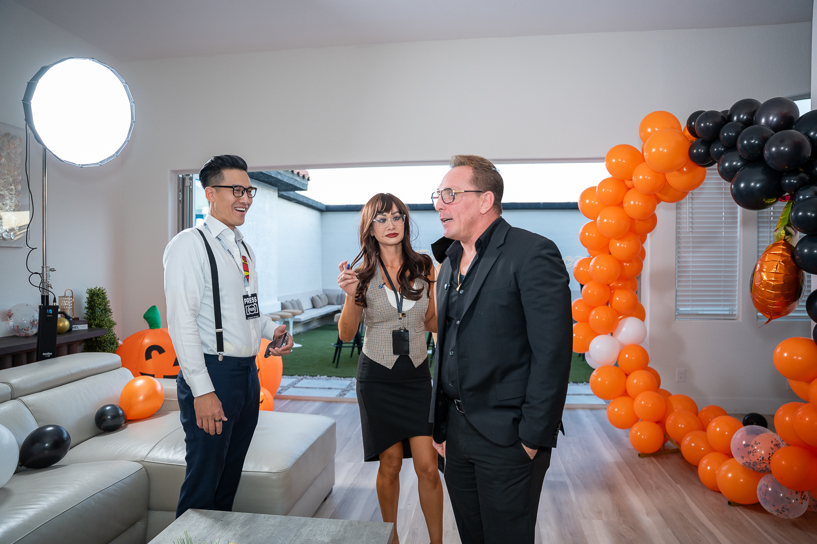 Catalina Magee talking with guests beside the orange balloon arch