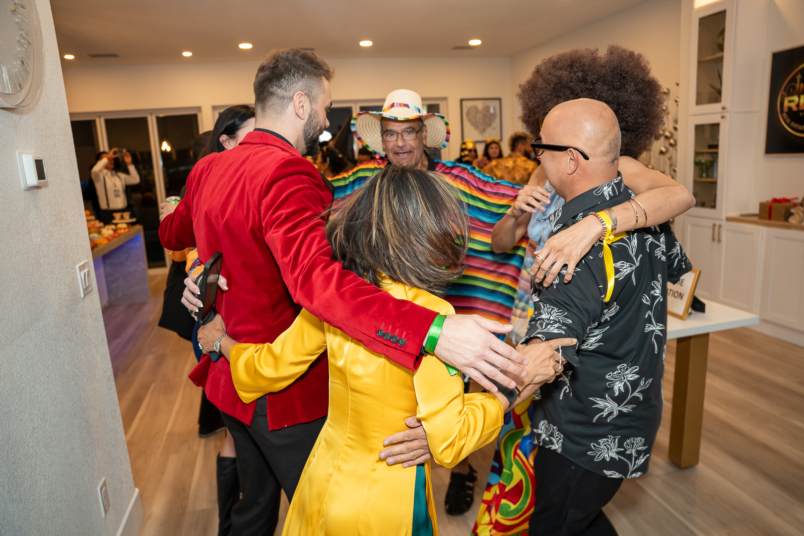 Friends in colorful Halloween costumes gathering for a group hug