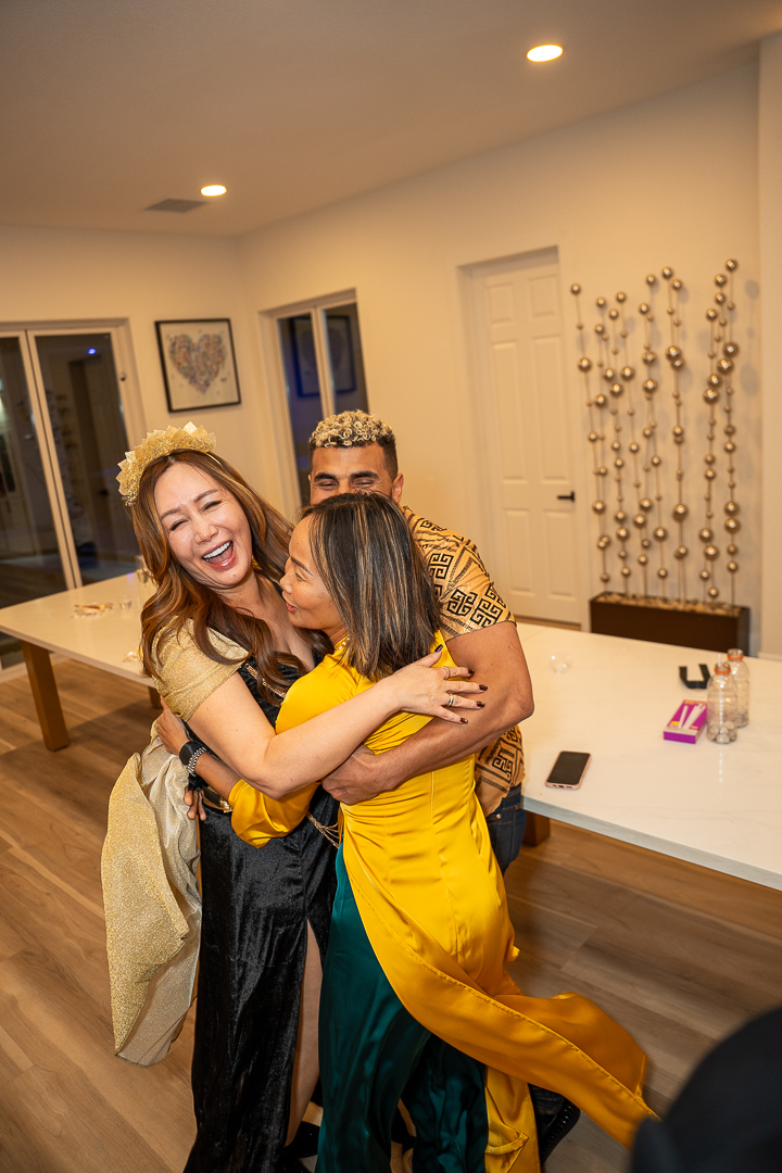 Two guests in gold and yellow costumes sharing a warm hug