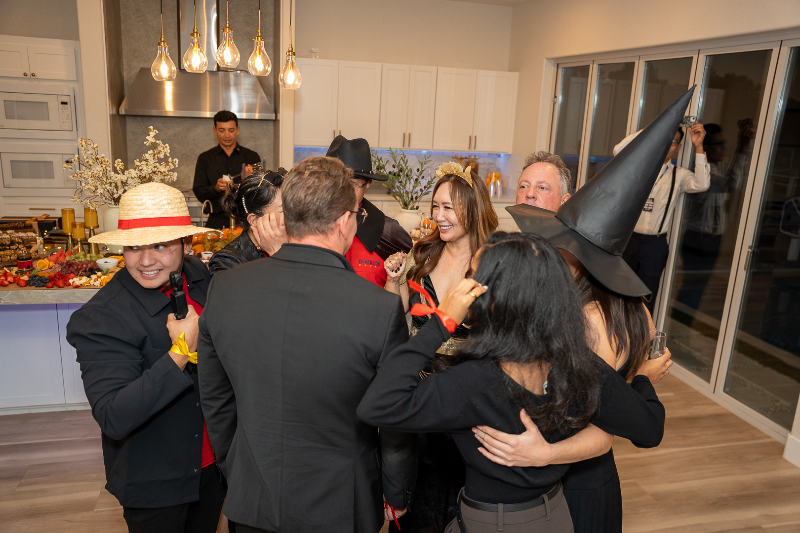 Guests mingling in Halloween costumes near the kitchen island